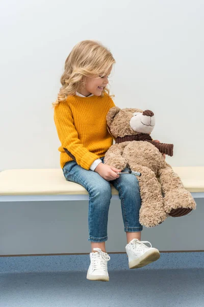 Chica haciendo neurología examen de osito de peluche - foto de stock