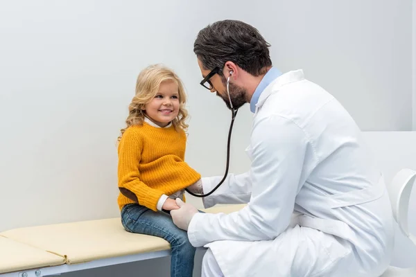 Pediatrist listening to breath of little girl — Stock Photo