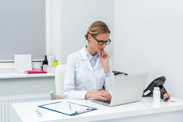 Médico femenino usando computadora portátil - foto de stock