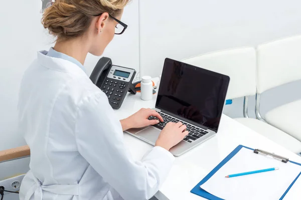 Médico femenino usando computadora portátil - foto de stock