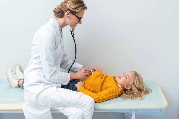 Médecin écoute souffle de petite fille — Photo de stock