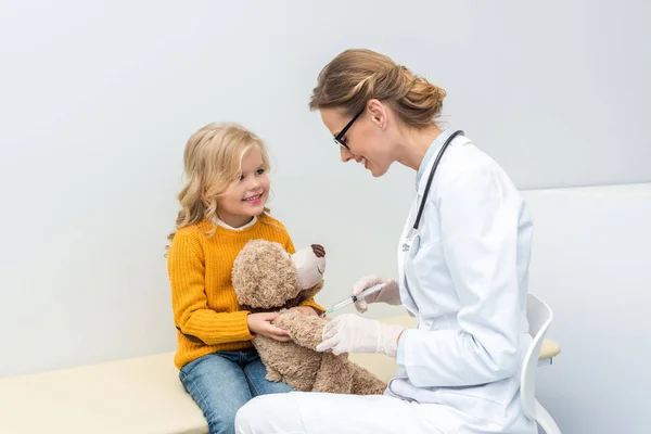 Doctor doing injection for teddy bear — Stock Photo