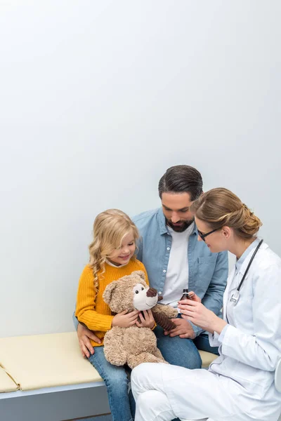 Doctor giving syrup to teddy bear — Stock Photo