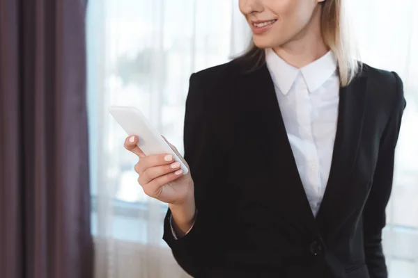 Femme d'affaires avec smartphone dans la chambre d'hôtel — Photo de stock