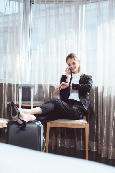 Femme d'affaires utilisant un smartphone dans la chambre d'hôtel — Photo de stock