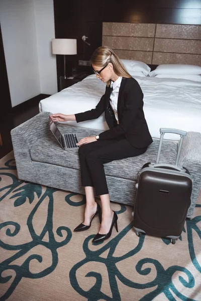 Femme d'affaires utilisant un ordinateur portable dans la chambre d'hôtel — Photo de stock