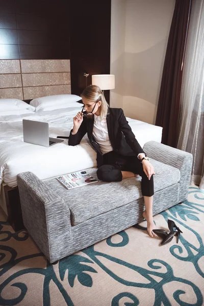 Empresaria usando laptop en habitación de hotel - foto de stock