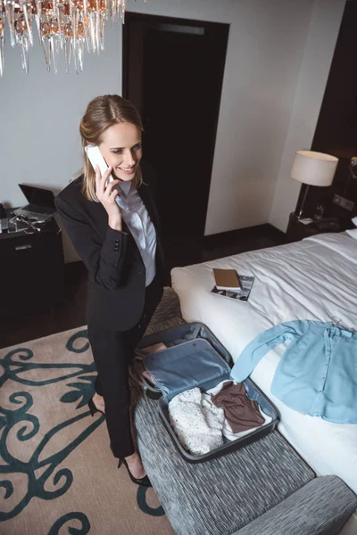 Femme d'affaires utilisant un smartphone dans la chambre d'hôtel — Photo de stock