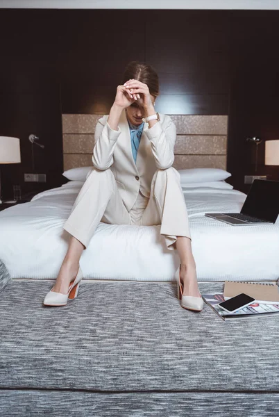 Mujer de negocios sobrecargada de trabajo en habitación de hotel - foto de stock