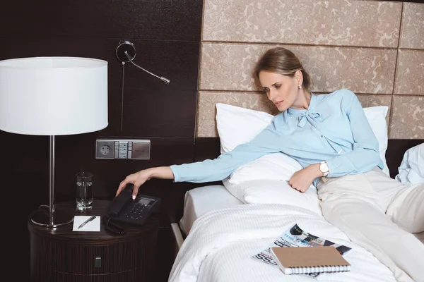 Businesswoman talking by phone in hotel — Stock Photo