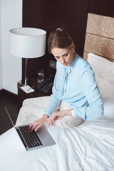 Empresária usando laptop no quarto de hotel — Fotografia de Stock