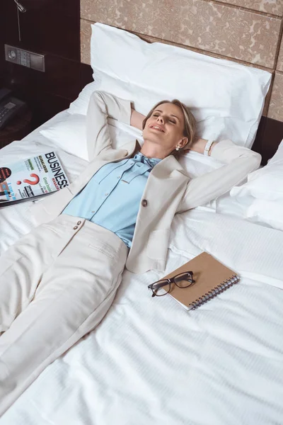Felice donna d'affari sul letto in hotel — Foto stock