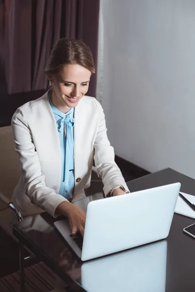 Femme d'affaires utilisant un ordinateur portable dans la chambre d'hôtel — Photo de stock