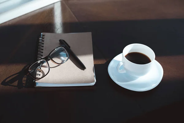 Taza de café y cuaderno - foto de stock