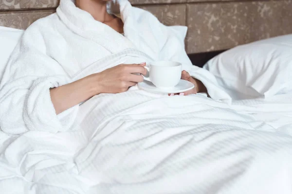 Woman in bathrobe drinking coffee — Stock Photo