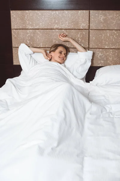 Жінка прокидається в готельному номері — стокове фото