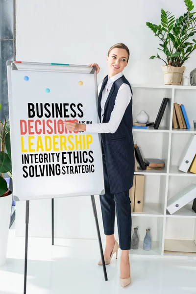 Businesswoman writing on whiteboard — Stock Photo