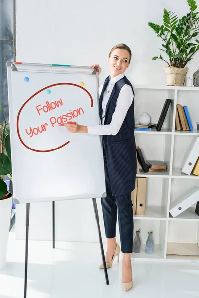 Businesswoman writing on whiteboard — Stock Photo