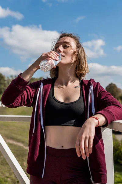 Mujer beber agua después del entrenamiento - foto de stock