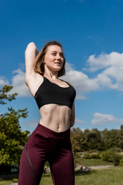 Mujer estirándose antes del entrenamiento - foto de stock