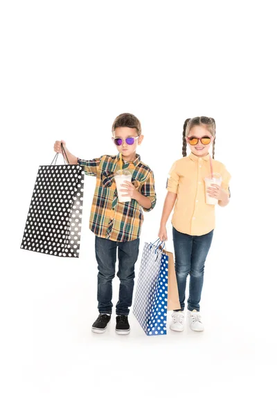 Enfants avec sacs à provisions et milkshakes — Photo de stock