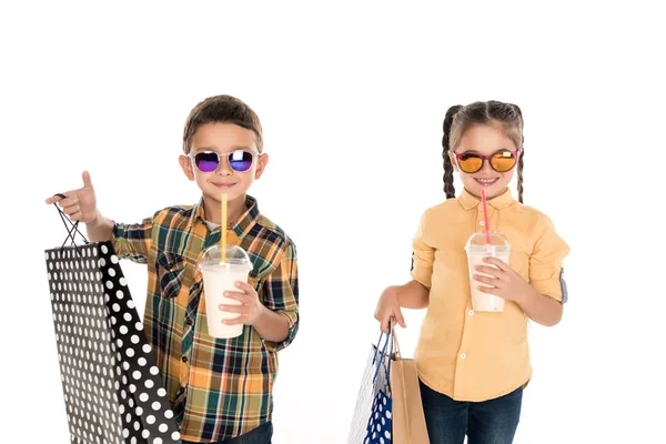 Siblings with shopping bags and milkshakes — Stock Photo