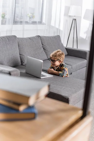 Маленький мальчик смотрит на ноутбук — стоковое фото