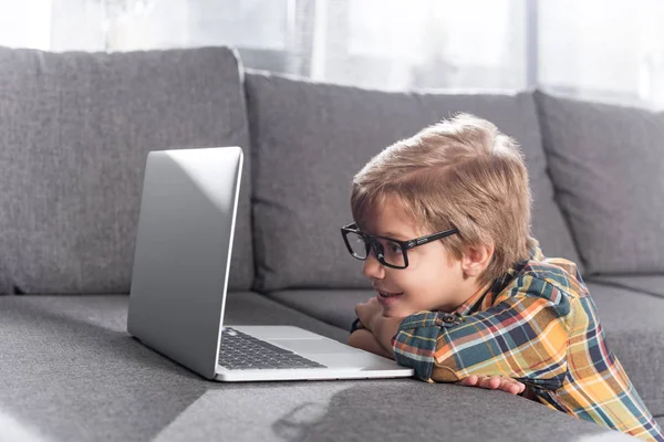 Маленький мальчик смотрит на ноутбук — стоковое фото