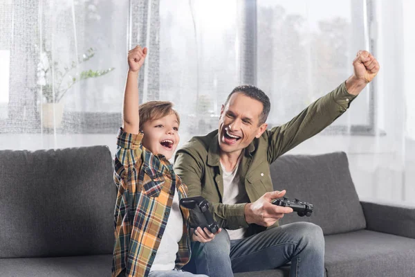 Padre e hijo jugando videojuego - foto de stock