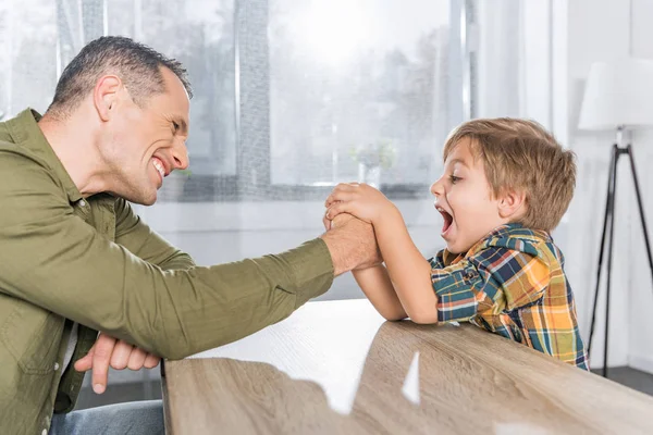 Father and son arm wrestling together — Stock Photo