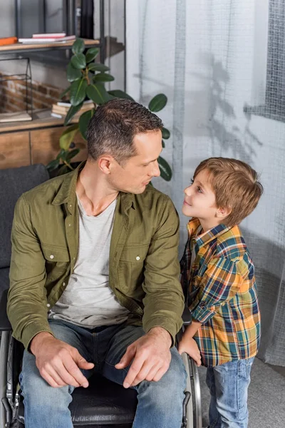 Padre en silla de ruedas e hijo - foto de stock