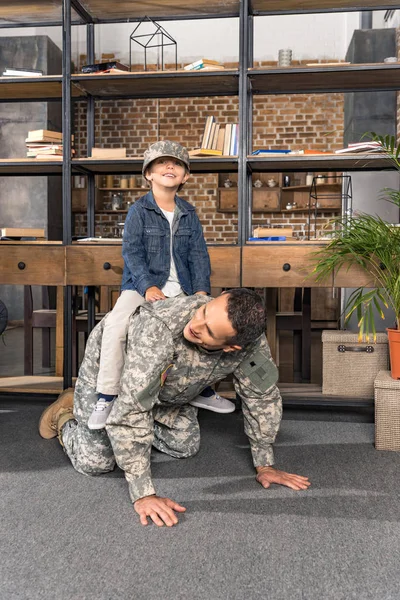 Father and son piggybacking at home — Stock Photo