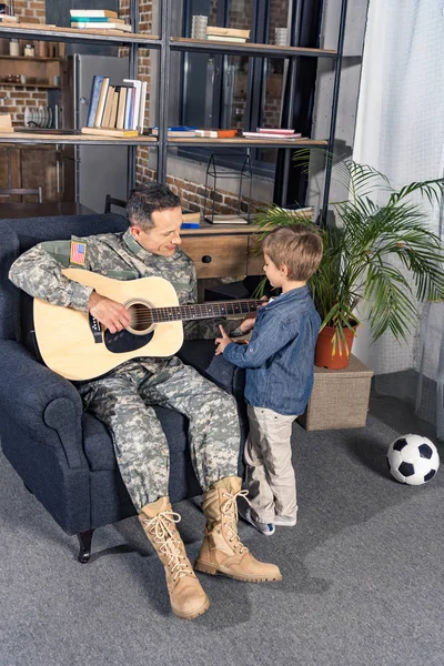 Мужчина играет на гитаре для сына — стоковое фото