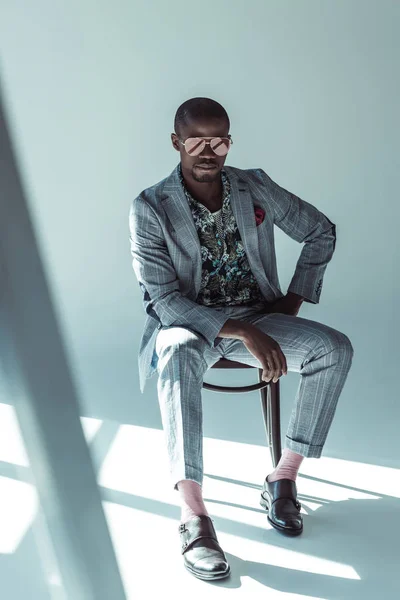 Elegante hombre de traje posando en silla - foto de stock