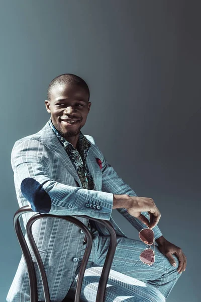 Élégant homme afro-américain assis sur une chaise — Photo de stock