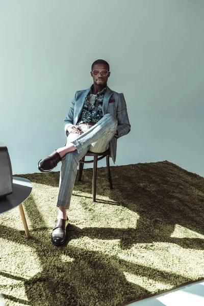 Man in stylish suit posing on chair — Stock Photo