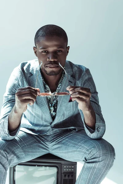 Homme élégant assis sur la télévision rétro — Photo de stock