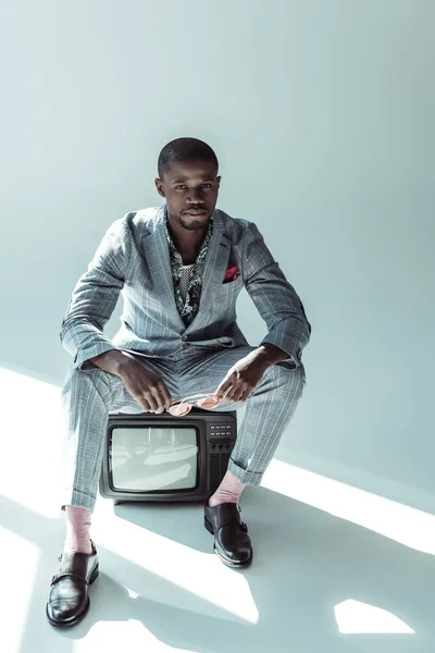 Homme élégant assis sur la télévision rétro — Photo de stock