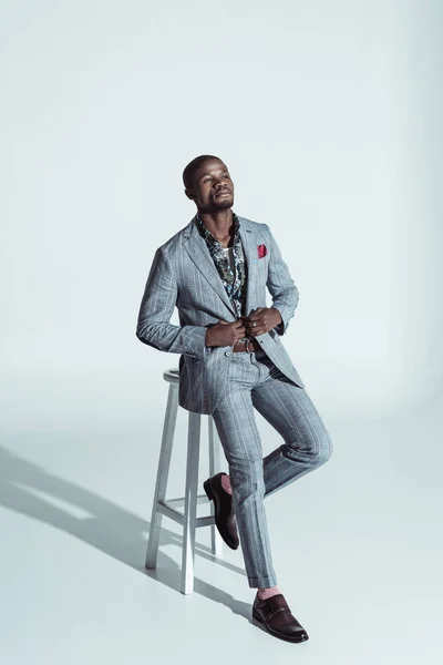 Афроамериканський чоловік у костюмі на барній стільці — стокове фото
