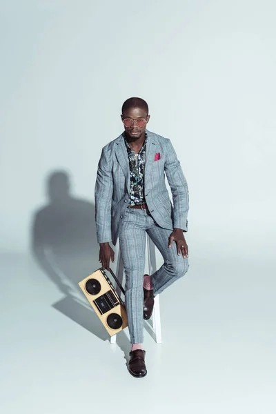 Homme sur tabouret de bar tenant boombox — Photo de stock