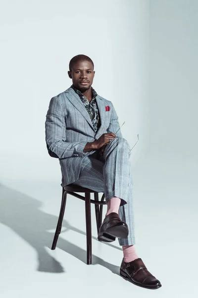 Afro-américain en costume sur chaise — Photo de stock