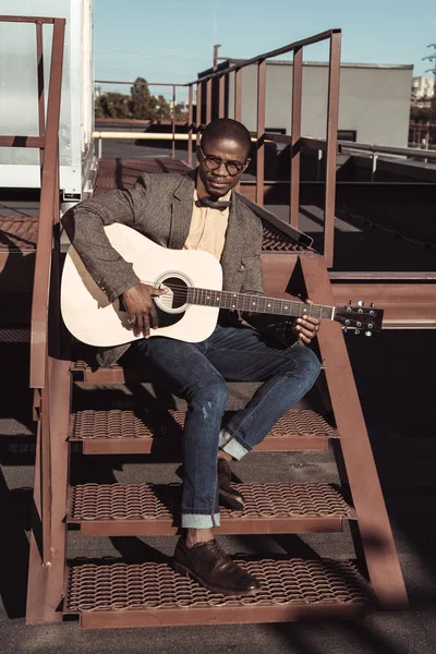 Африканский американец на лестнице играет на гитаре — стоковое фото