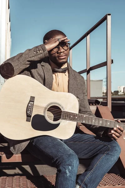 Jovem nas escadas tocando guitarra — Fotografia de Stock