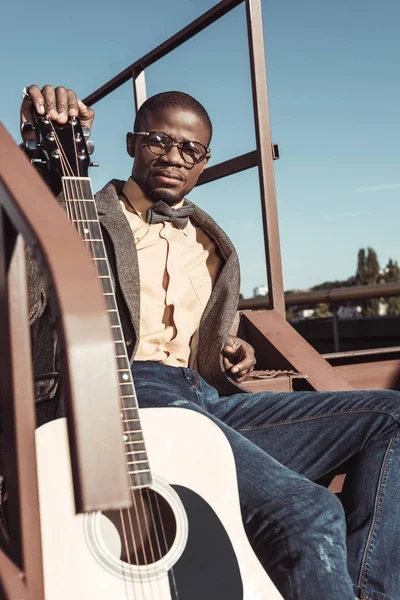 Homem elegante posando em escadas com guitarra — Fotografia de Stock