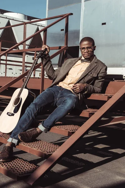 Homem posando em escadas com guitarra — Fotografia de Stock