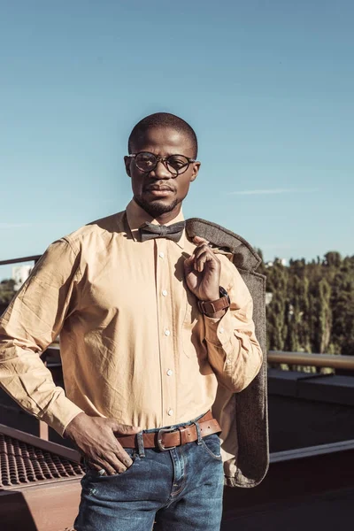 Elegante hombre sosteniendo chaqueta en el hombro - foto de stock