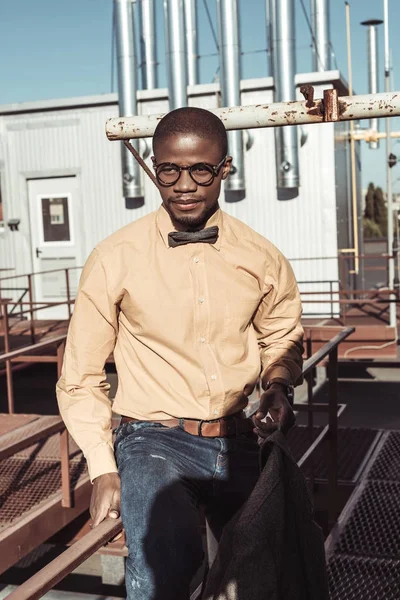 Junger Afroamerikaner sitzt auf Leitplanke — Stockfoto