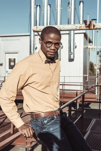 Stylish african american man sitting on guardrails — Stock Photo