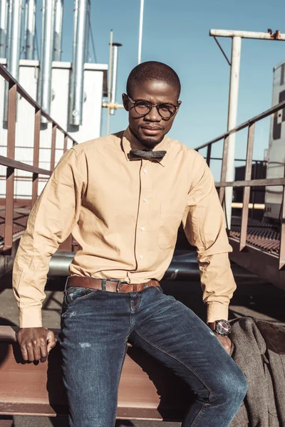 Homme afro-américain assis sur la construction métallique — Photo de stock