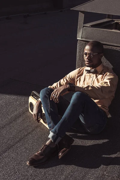 Stylish african american man sitting on rooftop — Stock Photo